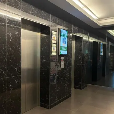 a row of elevators in a building with black tiles at The Gallery condominium in Samut Prakan