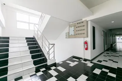 a staircase in a building with a checkered floor at Ruan Plaisoi Apartment in Bangkok