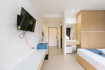 a hotel room with a television on a wall at Ruan Plaisoi Apartment in Bangkok