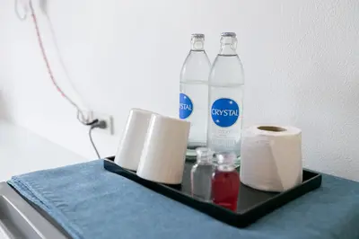 a shelf with two bottles of water and toilet paper at Ruan Plaisoi Apartment in Bangkok
