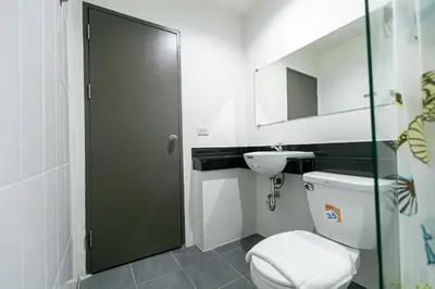 a bathroom with a toilet and a sink at Ruan Plaisoi Apartment in Bangkok