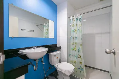 a bathroom with a sink and a toilet and a mirror at Ruan Plaisoi Apartment in Bangkok