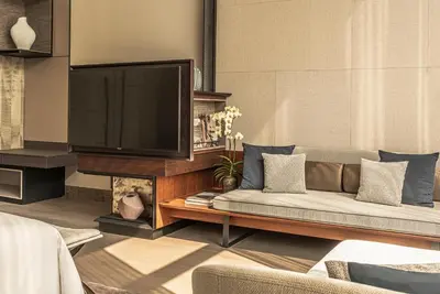 a living room with a couch and a television at Four Seasons Hotel Bangkok at Chao Phraya River in Bangkok