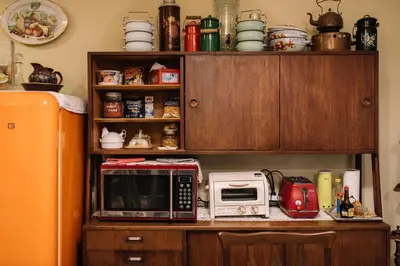 a kitchen counter with a microwave and a refrigerator at Lhong Yaowarat hostel in Bangkok