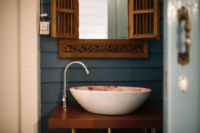 a bathroom with a white bowl sink with a faucet at Lhong Yaowarat hostel in Bangkok