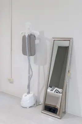 a lamp and a mirror next to a floor lamp at Bai Bua House Chatuchak in Ban Zong Katiam