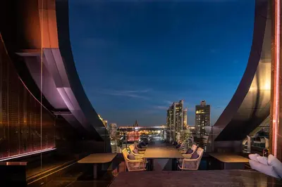 a view of the city from a balcony at night at Carlton Hotel Bangkok Sukhumvit in Bangkok