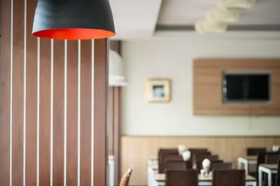 a dining room with tables and chairs and a red light at Marsi Hotel Bangkok in Bangkok