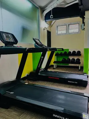 a treadmill in a gym with a table at 42Grand Residence in Bangkok