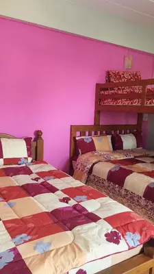 two beds in a room with pink walls at Vanlisut Hotel Ngamwongwan in Nonthaburi