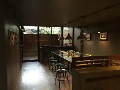 a kitchen with a counter and stools in a room at In a Box Hostel in Bangkok