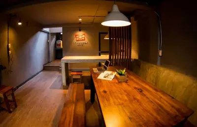 a living room with a wooden table and a bench at In a Box Hostel in Bangkok