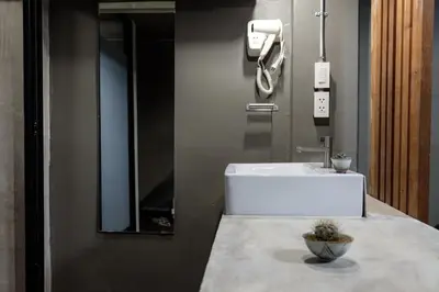 a bathroom with a white sink on a counter at In a Box Hostel in Bangkok