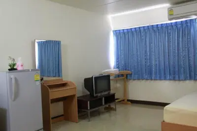 a room with a refrigerator and a tv in it at Baan Khun Rak in Bangkok