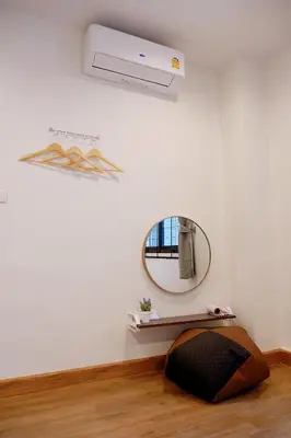 a room with a white wall with a mirror at Lisa'House in Bangkok