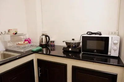 a kitchen counter with a microwave and a sink at Lisa'House in Bangkok