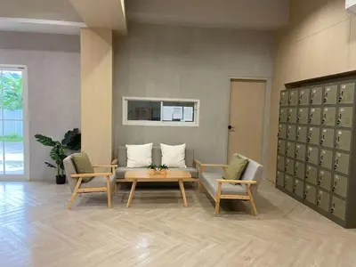 a living room with two chairs and a couch and a table at Next Bird Suite SHA in Nonthaburi