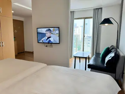 a hotel room with a bed and a tv on a wall at Pentafield City Residence in Amphoe Phra Khanong