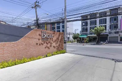 a sign on a brick wall next to a street at The Excel Groove Condo at Lasalle 52 in Bangkok