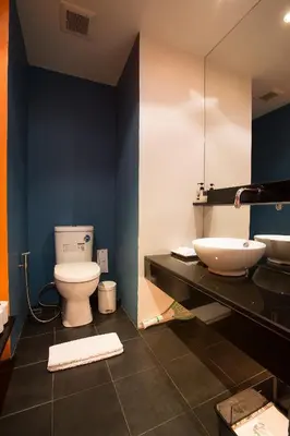 a bathroom with a white toilet and a sink at Loogchoob Homestay in Bangkok