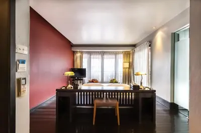 a room with a tub and a table and a chair at Loogchoob Homestay in Bangkok