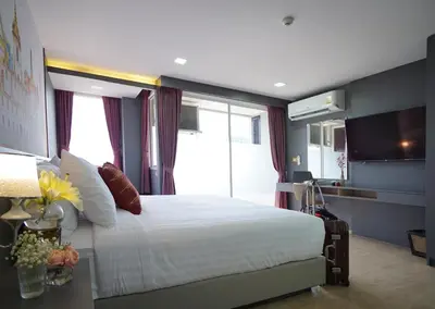 a bedroom with a large bed and a large window at The Qube fifty Hotel in Bangkok