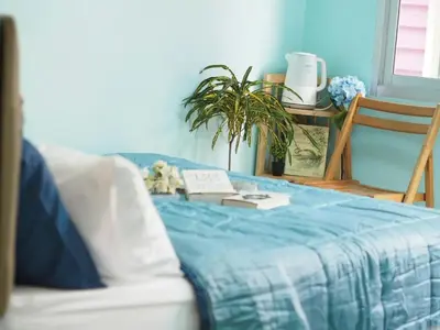 a couch with a blue blanket on top of it at Makkasan Happy Home in Bangkok