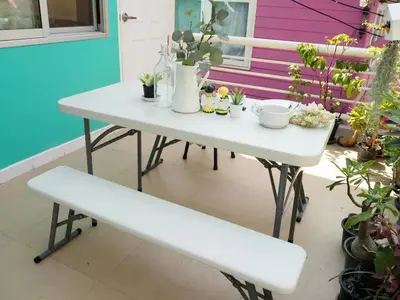 a white table and bench on a patio with plants at Makkasan Happy Home in Bangkok