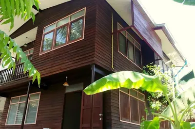 a wooden house with a brown door and windows at Yesterday Sathon in Bangkok