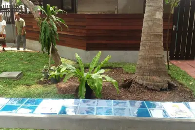 a garden with a palm tree in front of a house at Yesterday Sathon in Bangkok