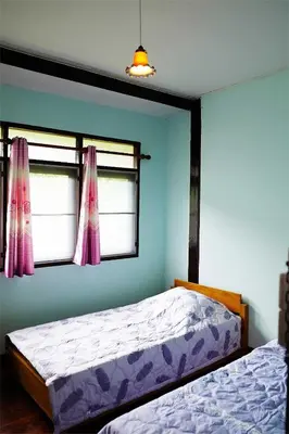 a bedroom with two beds and a window at Yesterday Sathon in Bangkok