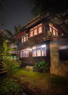 a wooden house with lights on in the yard at Yesterday Sathon in Bangkok