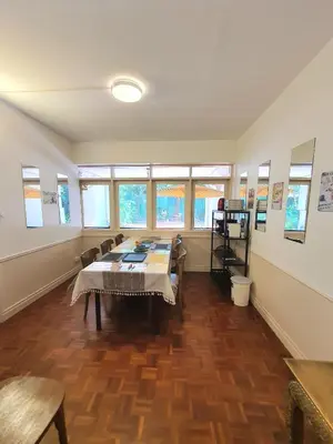a room with a long table with chairs and windows at Villa Thaï Sukhumvit Asok Nana in Bangkok