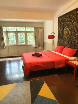 a bedroom with a large bed with red sheets at Villa Thaï Sukhumvit Asok Nana in Bangkok