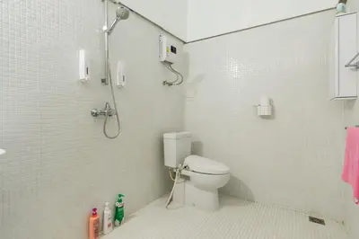 a white bathroom with a shower and a toilet at Villa Thaï Sukhumvit Asok Nana in Bangkok