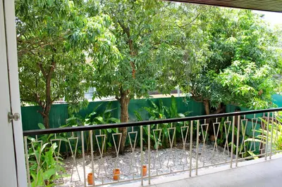 a balcony with a black fence and trees at Villa Thaï Sukhumvit Asok Nana in Bangkok