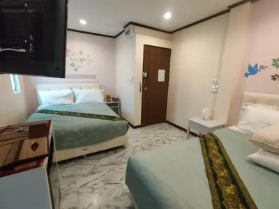 a hotel room with two beds and a flat screen tv at Cana Boutique Hotel in Bangkok