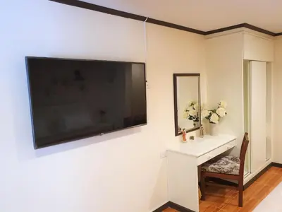 a bathroom with a sink and a large television on the wall at Cana Boutique Hotel in Bangkok