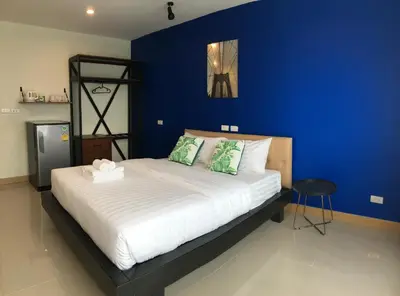 a bedroom with a large bed with a blue wall at Thanks​Pama​ in Bang Khen