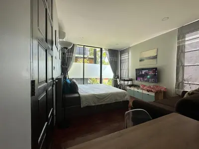 a bedroom with a bed and a couch and a window at PomPom Home in Bangkok