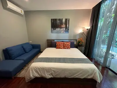 a bedroom with a bed and a blue couch at PomPom Home in Bangkok