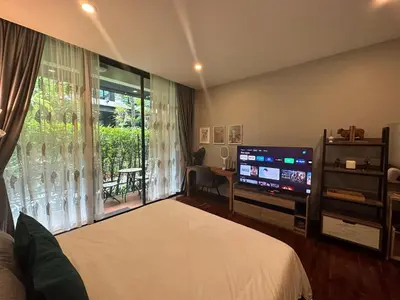 a bedroom with a bed and a flat screen tv at PomPom Home in Bangkok