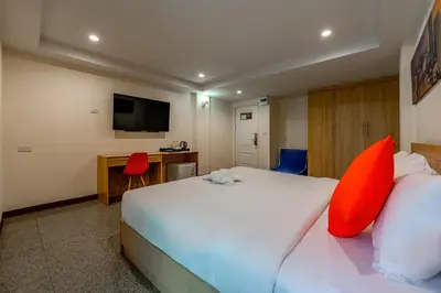 a hotel room with a large white bed with red pillows at 7 Days Premium Hotel at Icon Siam Station - No Parking in Bangkok