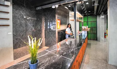 a woman standing at a counter in an office at 7 Days Premium Hotel at Icon Siam Station - No Parking in Bangkok