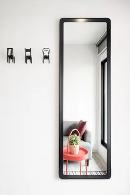 a mirror in a living room with a table and a couch at China Cozy Asoke in Bangkok