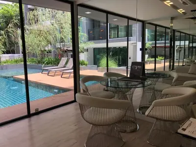 a conference room with a table and chairs and a pool at Comfy Condo On Nut in Bangkok