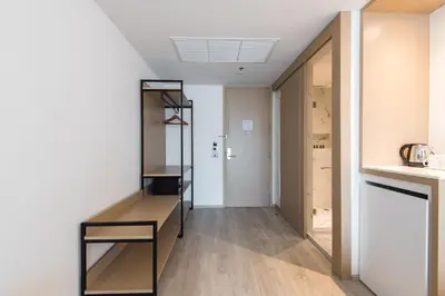 a room with a shelf and a hallway at Madison Bangkok Hotel in Bangkok