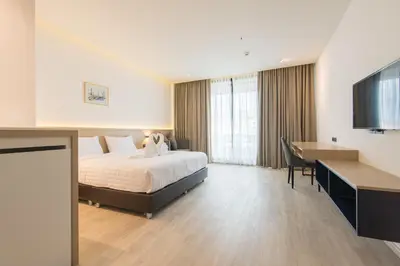 a hotel room with a bed and a desk at Madison Bangkok Hotel in Bangkok