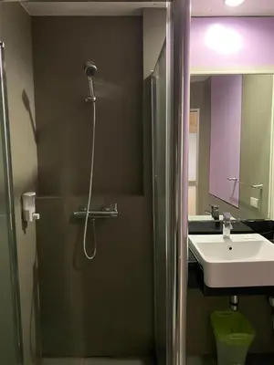 a bathroom with a shower and a sink at Vinary Hotel Sukhumvit in Bangkok