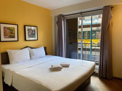 a bedroom with a bed with two towels on it at Vinary Hotel Sukhumvit in Bangkok